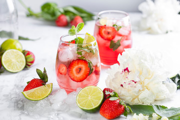 Pink lemonade with strawberries, lime, basil and mint