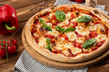 Pizza Margherita on wooden background, top view. Pizza Margarita with Tomatoes, Basil and Mozzarella Cheese close up. 