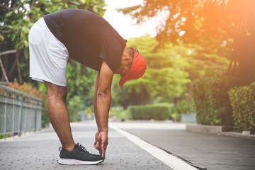 Young man runner stretching for warming up before running or working out