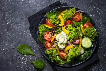 Fresh vegetables salad on black.