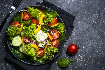 Fresh vegetables salad on black.