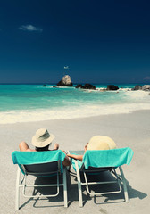 Couple on sunbeds relaxing at the beach in Lefkada