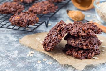 Flourless no bake peanut butter and oatmeal chocolate cookies on  parchment, horizontal, copy space