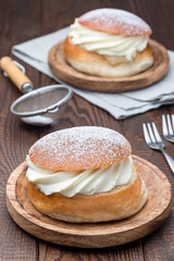 Traditional swedish dessert Semla, also called Shrove bun, with almond paste and whipped cream filling,  vertical
