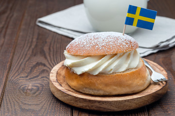 Traditional swedish dessert Semla, also called Shrove bun, with almond paste and whipped cream filling, served with  milk, horizontal, copy space