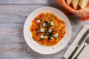 Turkish Scrambled Eggs with Tomatoes and Peppers on wooden table close-up