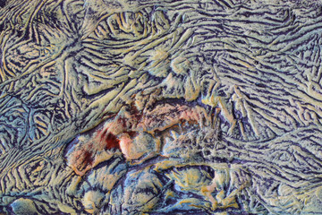 Background of old dried paint, bubbles and wrinkles, thick layer. Close-up.Fancy random color palette.