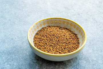 Yellow Mustard Seeds in Small Porcelain Bowl.