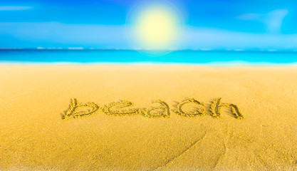 The yellow sand on the beach blue sea and the inscription beach