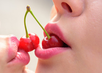 Obraz premium Lesbian Couple Together Concept. Kiss between girls. Cherry in the mouth. Relations. Creative kiss. Sexy concept.