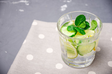 Cleansing drink of cucumber, lemon and mint on the table with a copy of space