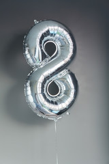 Silver color ballon number 8 on Happy birthday
