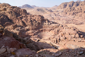 Roman Amphitheater in Petra carved out of a solid rock. Located in Jordan. Panoramic aerial view of the red desert landscape.