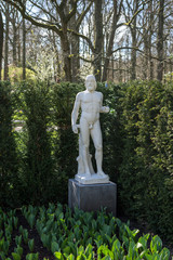 Obraz premium Flower garden, Netherlands , a statue of a person standing in front of a tree