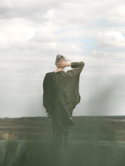 Stylish young woman posing in nature in street style clothing.
