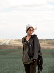 Stylish young woman posing in nature in street style clothing.