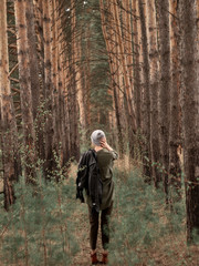 Stylish young woman posing in nature in street style clothing.