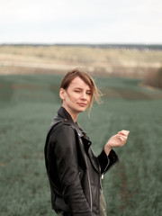 Stylish young woman posing in nature in street style clothing.