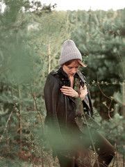Stylish young woman posing in nature in street style clothing.