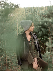 Stylish young woman posing in nature in street style clothing.