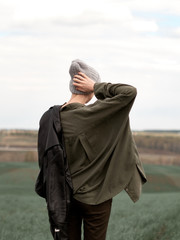 Stylish young woman posing in nature in street style clothing.