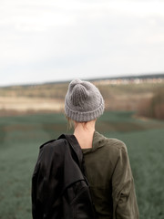 Stylish young woman posing in nature in street style clothing.