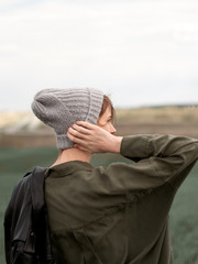 Stylish young woman posing in nature in street style clothing.