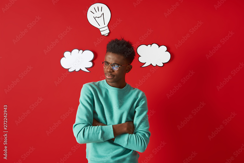 Wall mural Young African American man standing while crossing hands