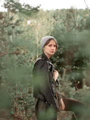 Stylish young woman posing in nature in street style clothing.