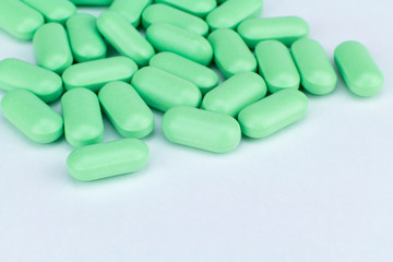Fototapeta na wymiar green pills on white background