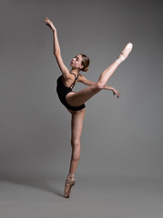 Fototapeta na wymiar Beautiful flexible ballerina dancing in studio