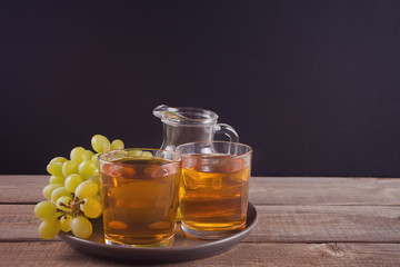 Gug and glasses of grape juice on the old wooden table