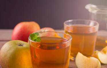 Apple juice and apples on wooden table. Selective focus