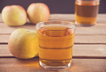 Apple juice and apples on wooden table. Selective focus