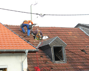 Elektriker arbeiten an Stromleitung auf dem Dach                