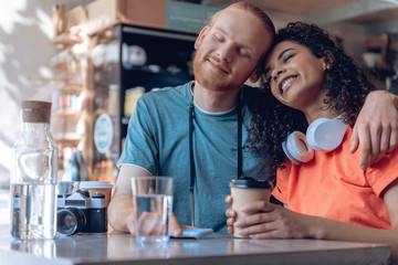 Young caring couple is enjoying themselves in cafeteria