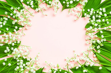 Fototapeta na wymiar Lilies of the valley on a pink background. Beautiful spring flowers. Greeting card. Wreath .Top view
