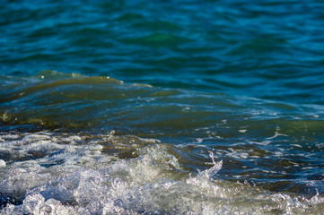 sea landscape is a pebbly beach with waves in white foam