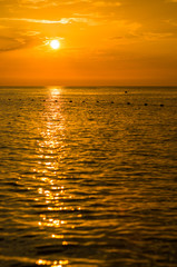 Amazing sea sunset on the pebble beach, the sun, waves, clouds