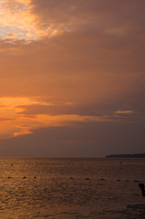 Amazing sea sunset on the pebble beach, the sun, waves, clouds