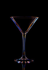 Glass for tequila against a black background, multi-colored contours.