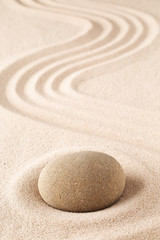 Fototapeta na wymiar Meditation stone on sand background. Concept for zen, harmony and purity.