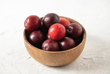 sweet fresh delicious red plums on bowl white wood table summer fruits