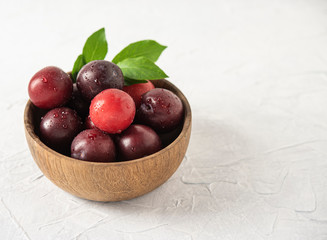 sweet fresh delicious red plums on bowl white wood table summer fruits