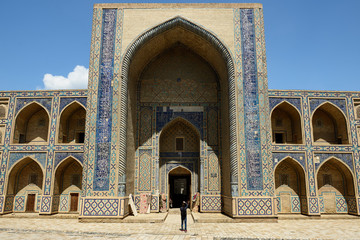 The tourist is making the photograph of the Medrese Ulugbeka in Bukhara, Uzbekistan.