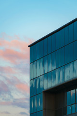 Fototapeta premium Modern building with curtain wall glass facade with cloudy sky reflections and background, black and white