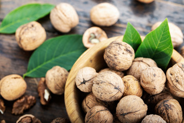 Walnut kernels and whole walnuts on rustic table.