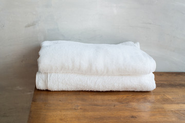 Fototapeta na wymiar White bath towel lies on a wooden table. Cement