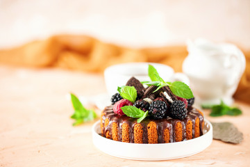 Cake in chocolate glaze with berries. Selective focus. Sweet summer dessert.