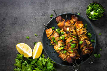 Grilled meat with herbs on black top view.